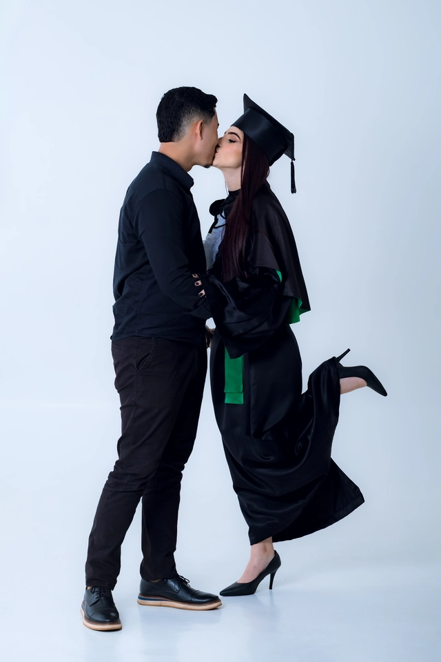 Formanda e namorado se beijando, ela com a perna erguida