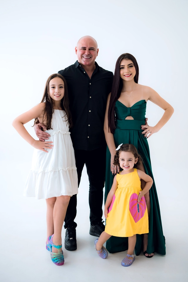 Formanda de vestido verde com o pai e as duas irmãs mais novas