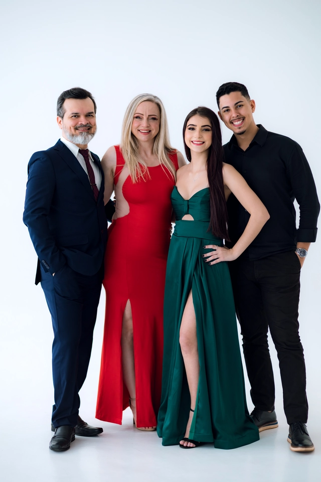 Formanda de vestido verde com o namorado e o casal de parentes