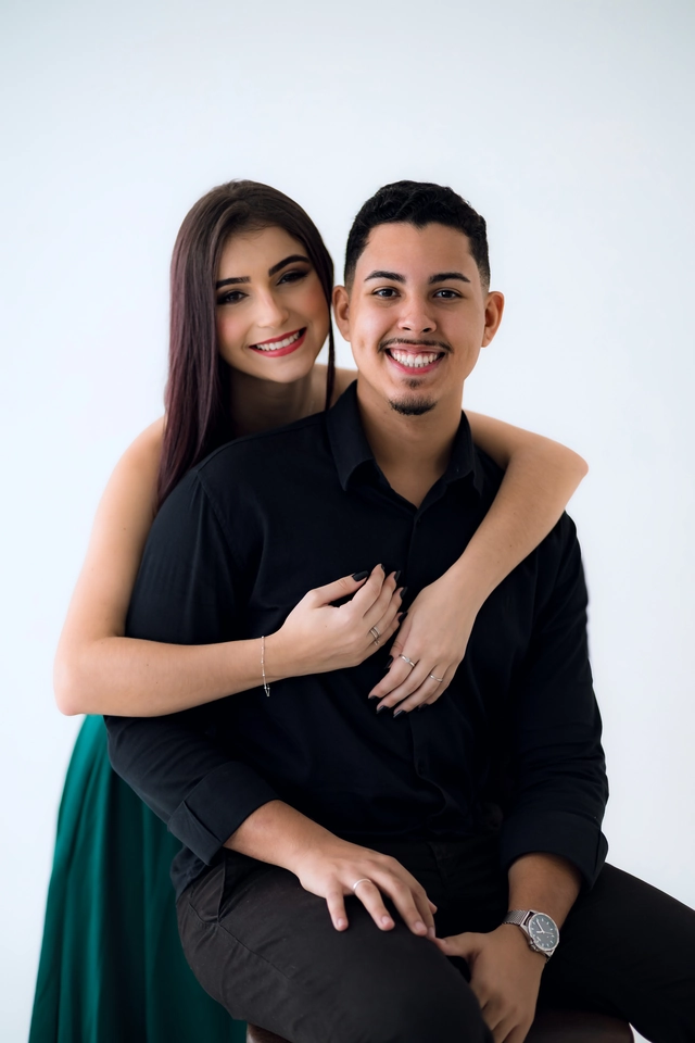 Formanda abraçando o namorado por trás, os dois sorrindo