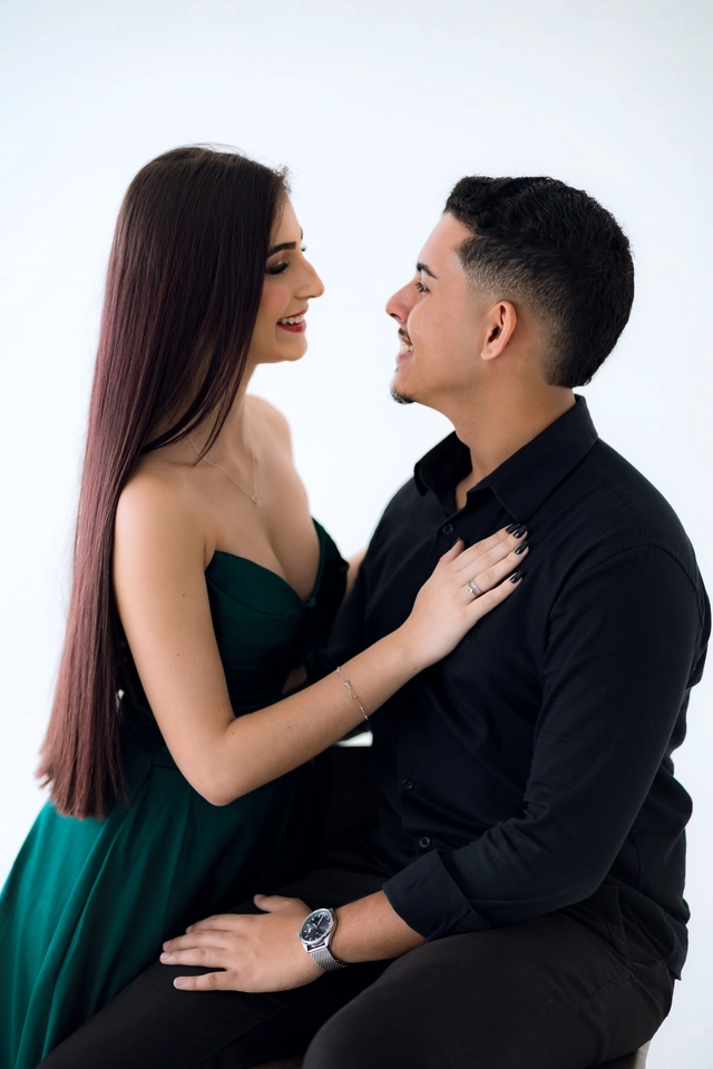 Formanda e namorado sentados de frente um pro outro, sorrindo