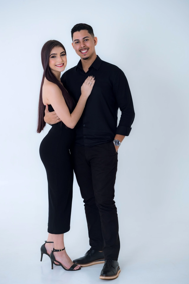 Formanda de vestido preto ao lado do namorado, corpo inteiro
