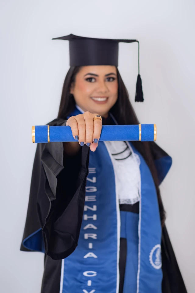Formanda estendendo o diploma em direção à câmera, fundo branco