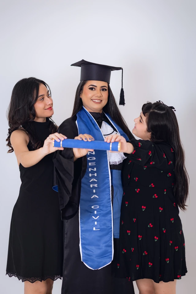 Formanda com a mãe e a irmã mais nova, entregando o diploma