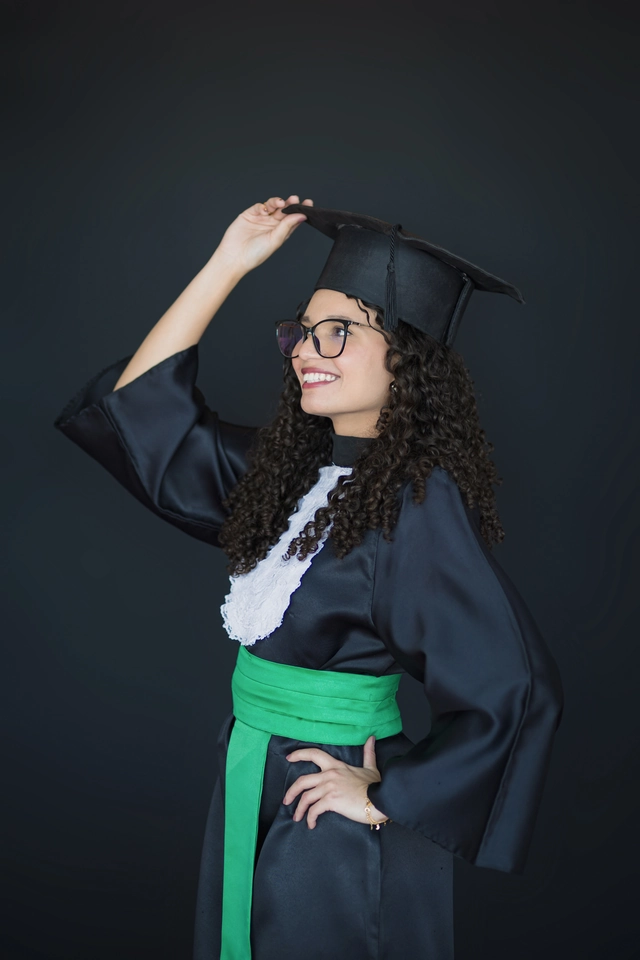 Formanda ajustando o capelo, retrato de formatura em estúdio