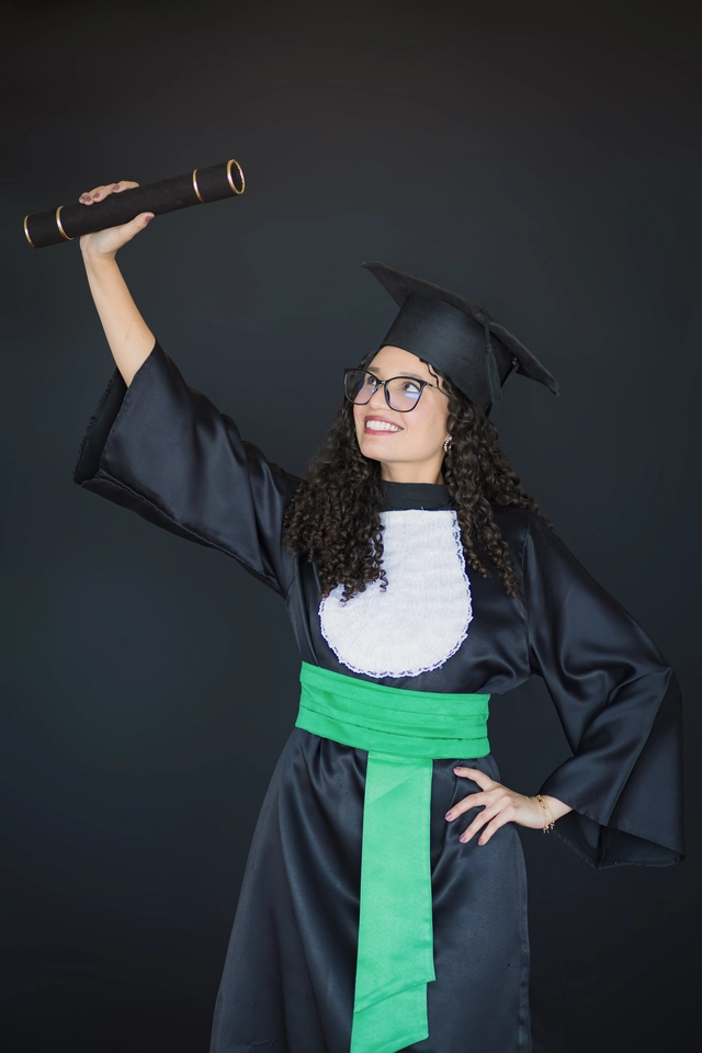 Formanda erguendo o diploma, retrato de formatura em estúdio